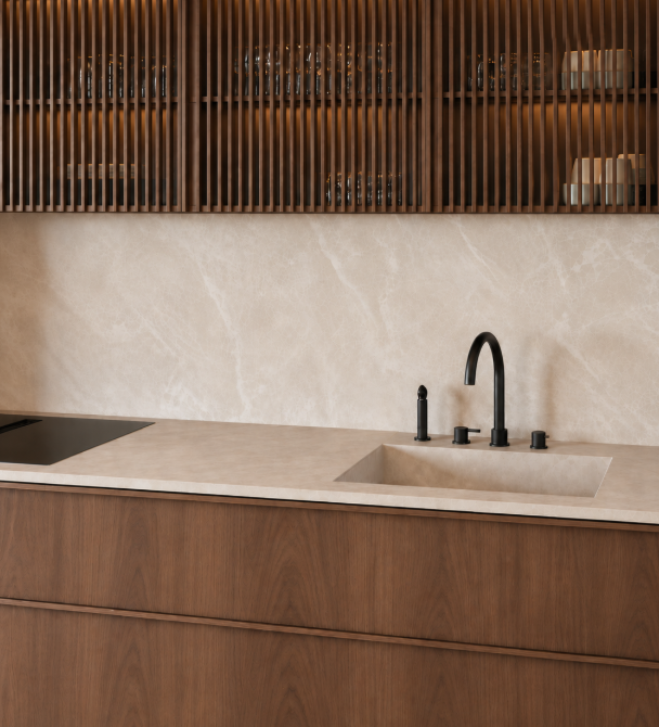 Cocina con encimera, fregadero frontal y respaldo en gran formato de Limepearl, con mobiliario de madera.