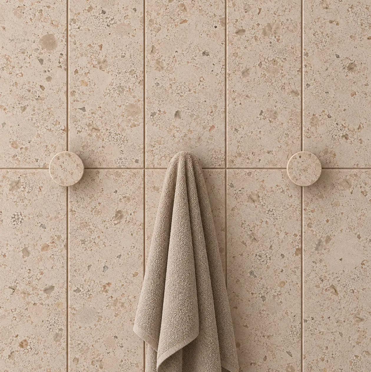 Ganchos y piezas mecanizadas de Limeaurea en placa de baño con toalla.