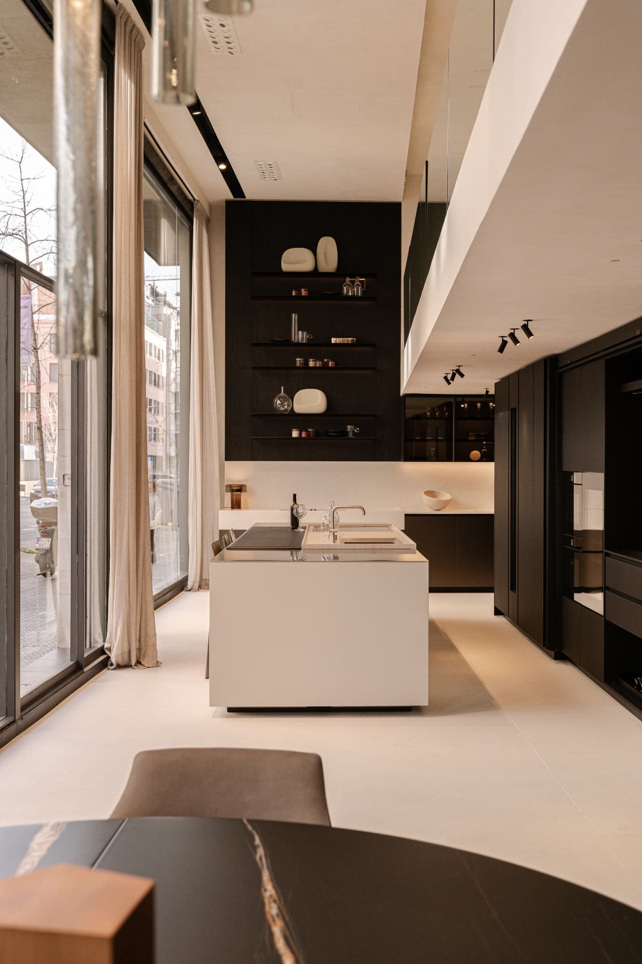 Main space of the Poliform Barcelona store with a continuous Limestucco Textured Piedra 10 ceiling and windows overlooking Via Augusta.